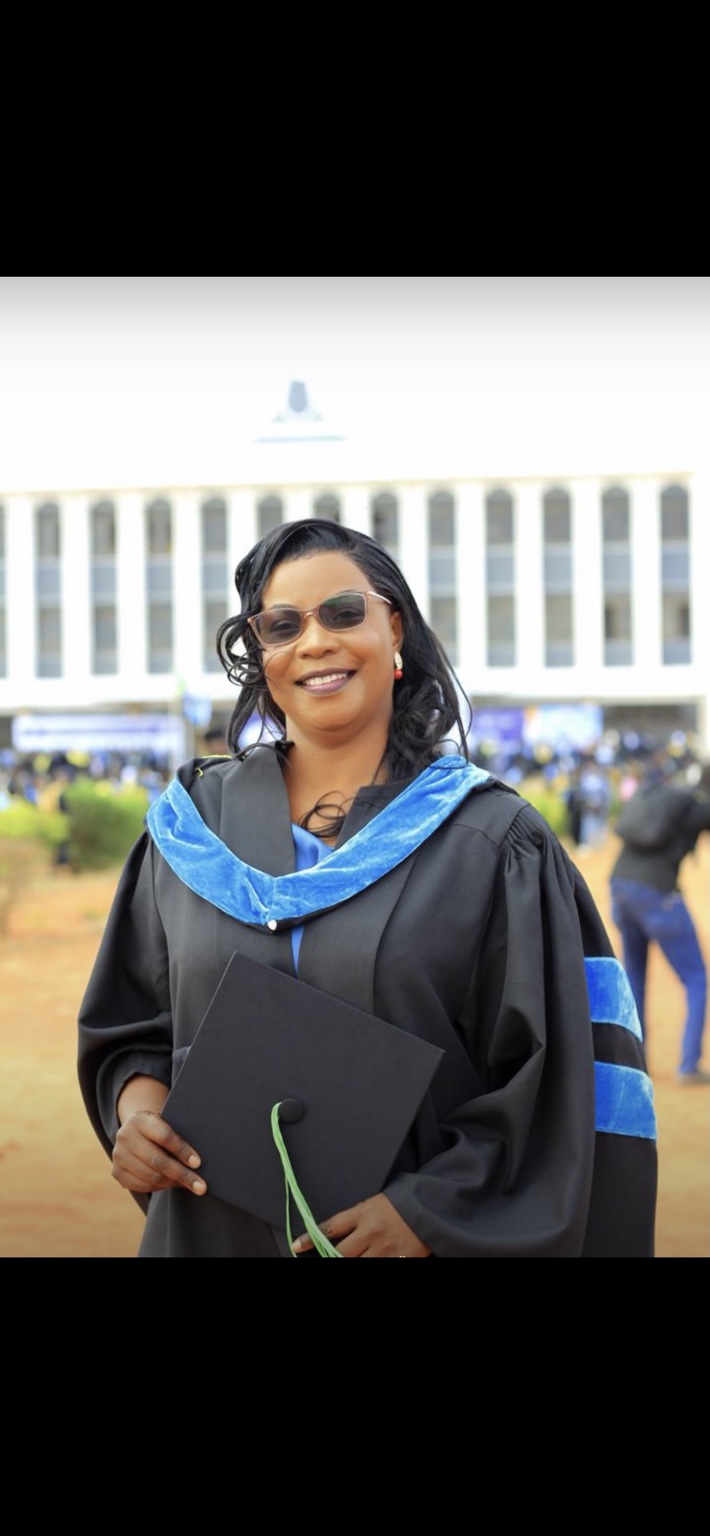 A postgraduate client holding a graduation folder
